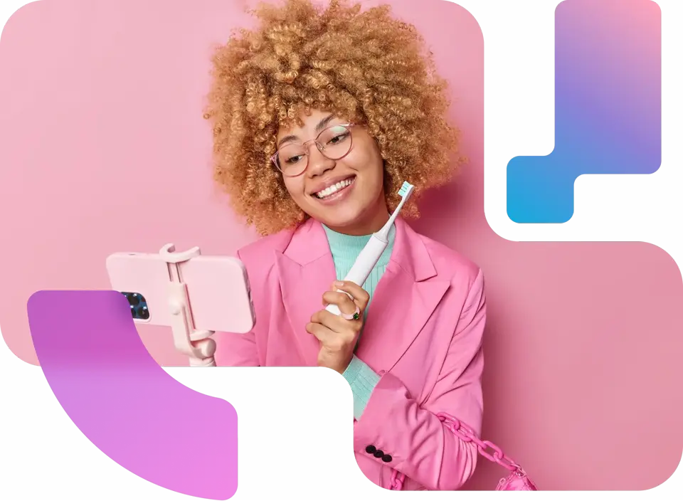 Girl holding a toothbrush taking a selfie with her iphone on a selfie stick