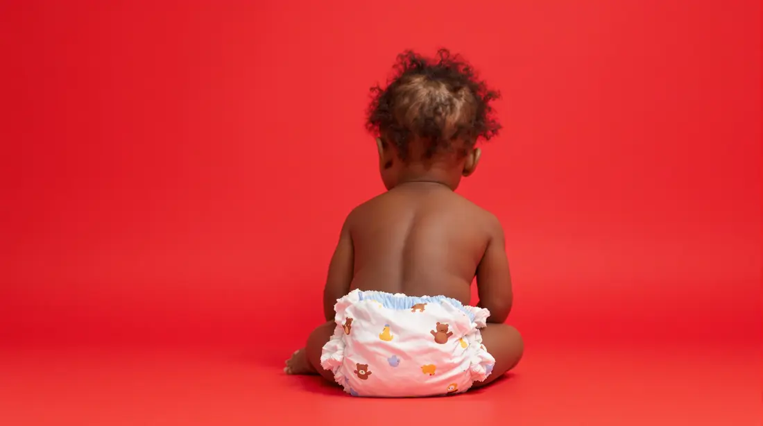 a baby sitting on the floor in a diaper