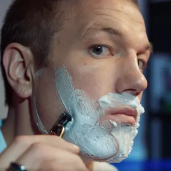 a man shaing his face with a gillette razor