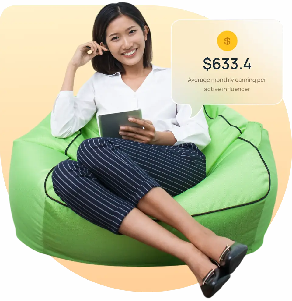 Woman sitting in a green bead bag holding an ipad with a text card above her displaying how much she earns per month